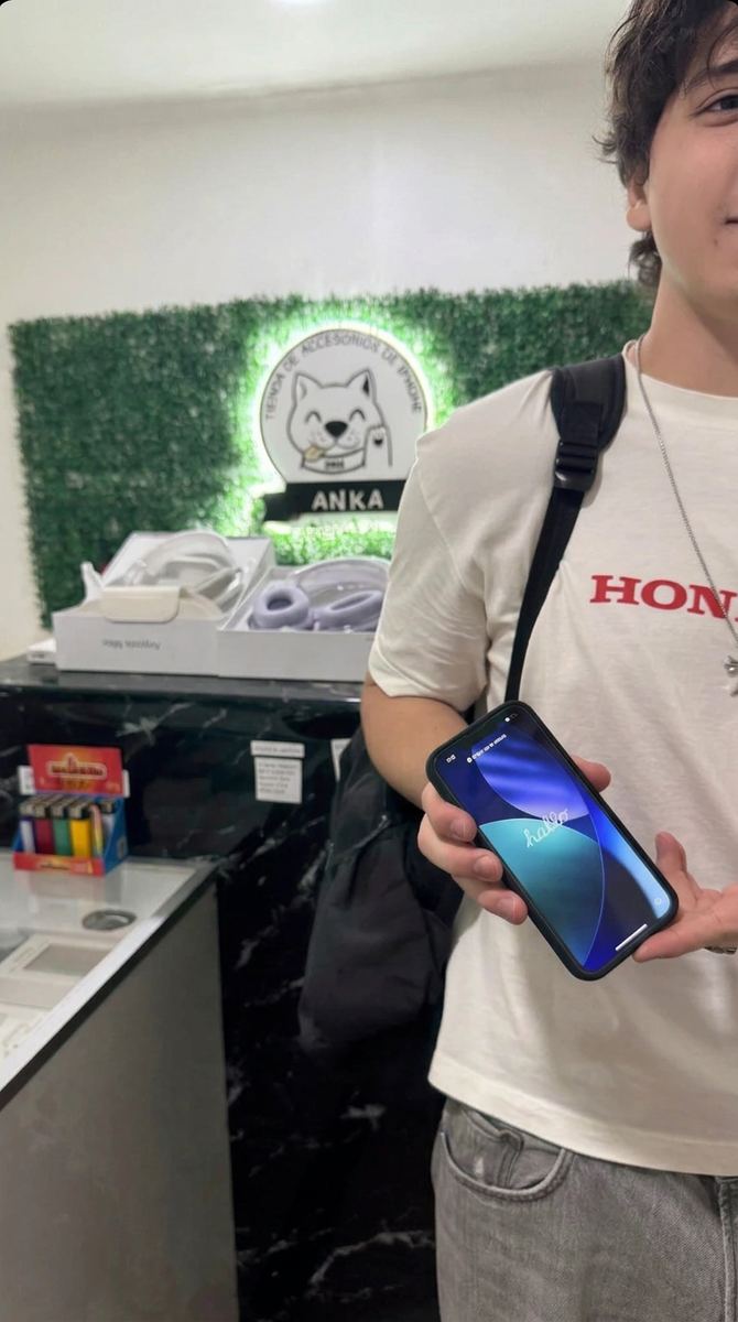 Cliente sonriendo con su iPhone 13 Pro nuevo en Ankita Store