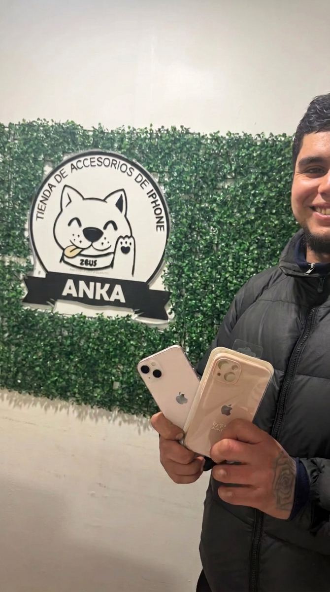 Cliente con dos iPhones con garantía frente al logo de Ankita Store